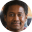 Profile avatar of a person with short dark hair wearing an orange shirt on a light blue background, used as a profile picture on a site.